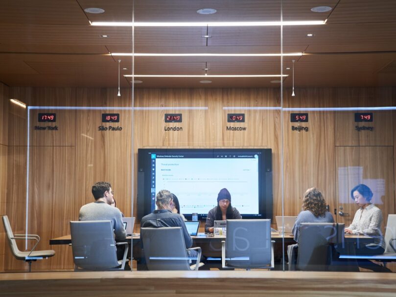 A group of people sitting at a table in a conference room.